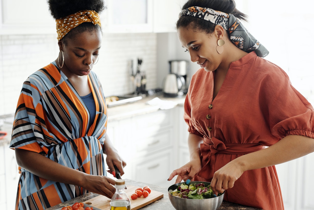 Two black women preparing food in the kitchen